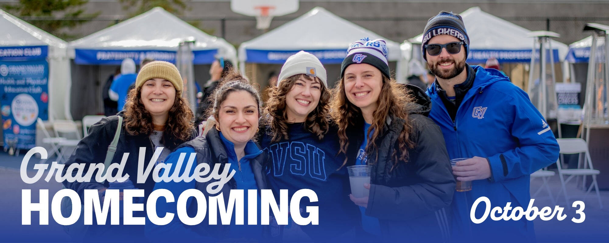 Group of alums smile at tailgate Homecoming October 3